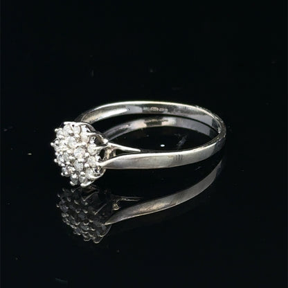 9ct white gold diamond cluster ring by Reeves and Sons featuring sparkling diamond accents and a elegant design.