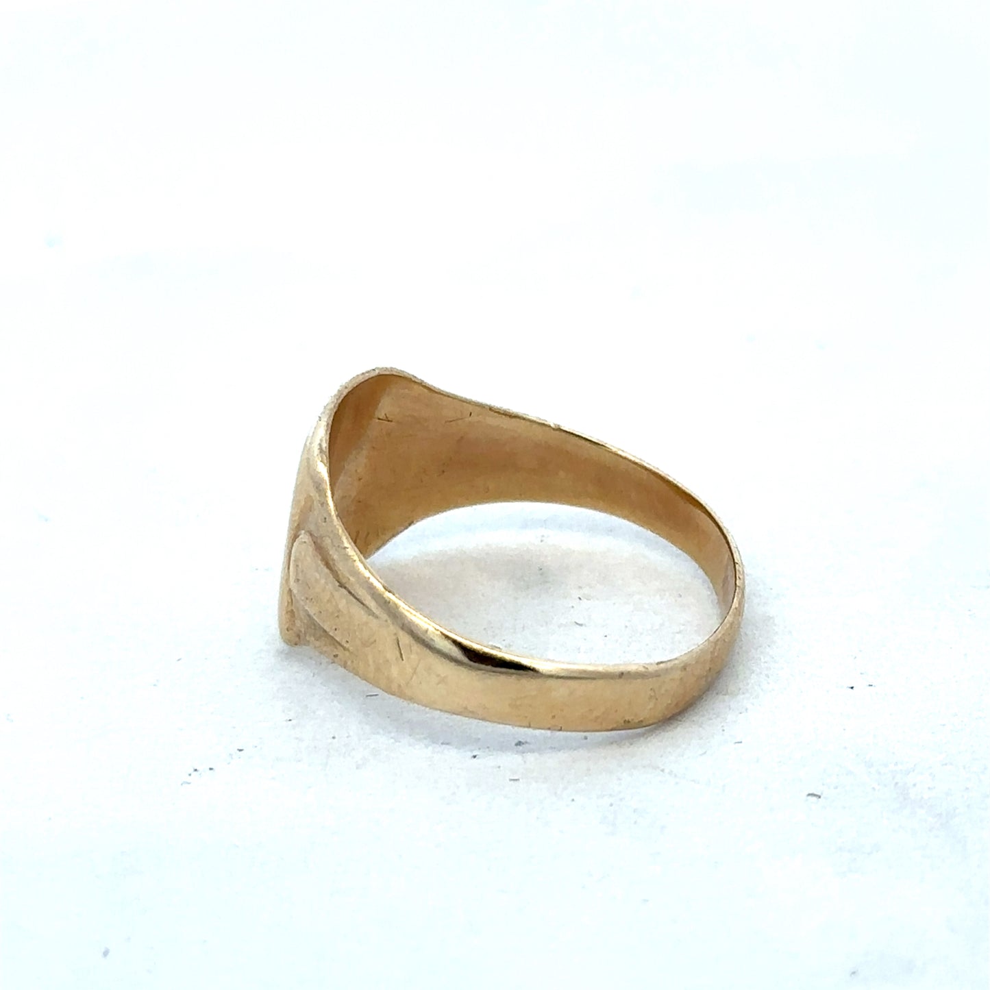 9ct yellow gold ring by Reeves and Sons, featuring a polished smooth band with subtle design details.