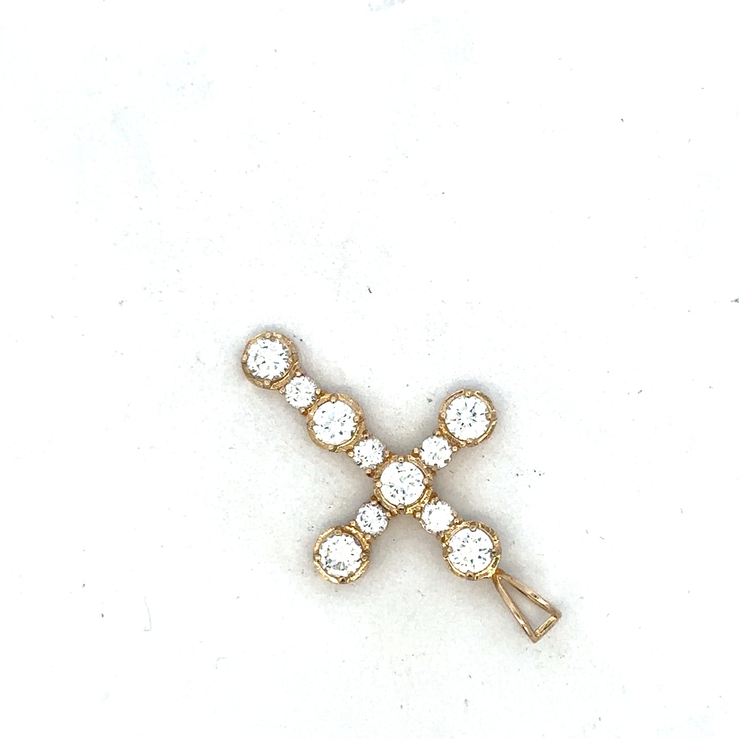 9ct yellow gold cross pendant by Reeves and Sons, showcasing a detailed religious jewelry design on a white background.