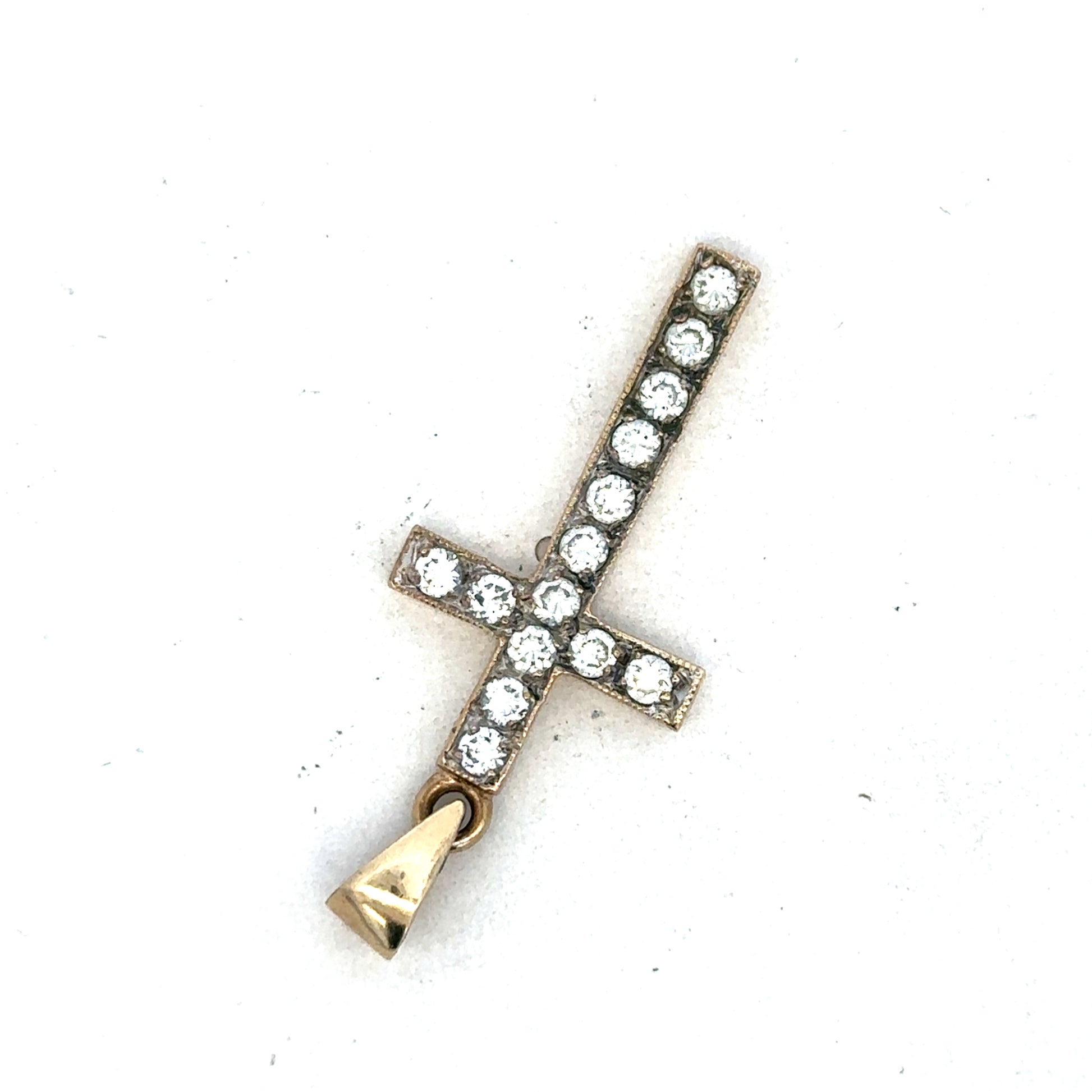 9ct yellow gold cross pendant by Reeves and Sons, featuring a detailed religious design, photographed against a neutral background.