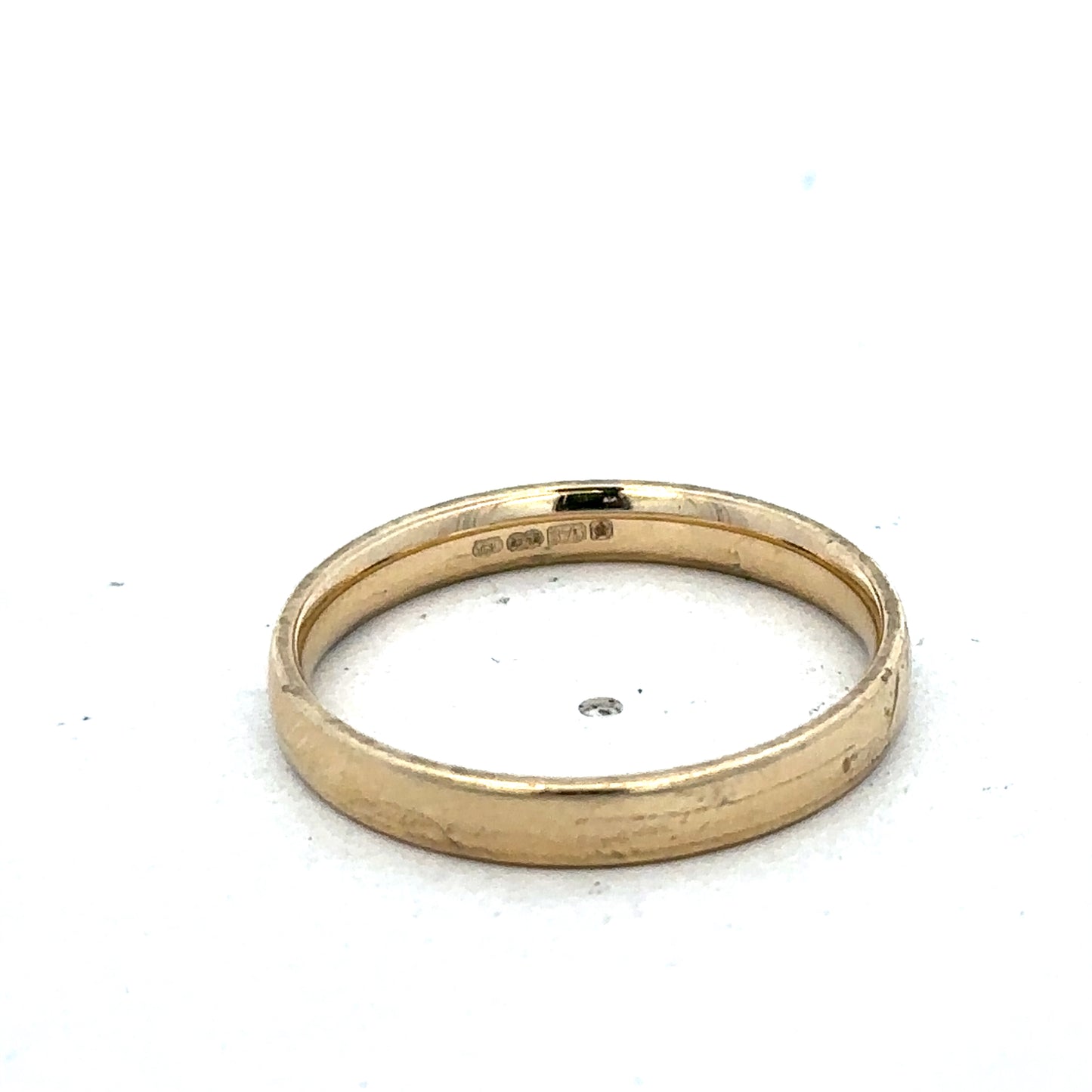 9ct yellow gold ring in size T with a smooth band, crafted by Reeves and Sons, shown on a plain background.