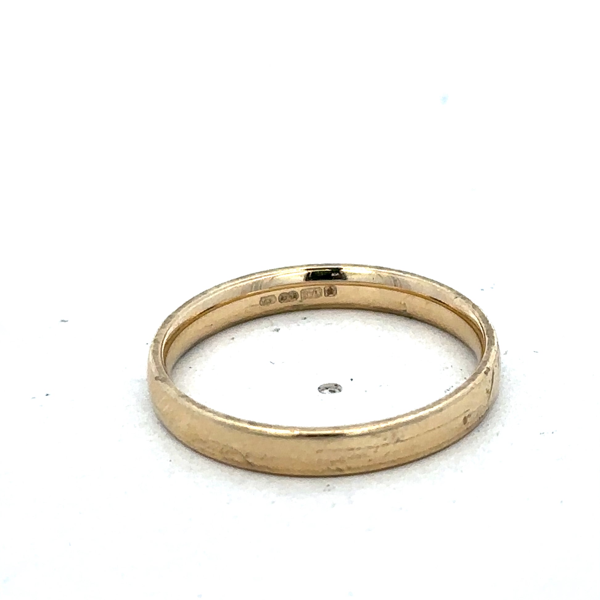 9ct yellow gold ring in size T with a smooth band, crafted by Reeves and Sons, shown on a plain background.