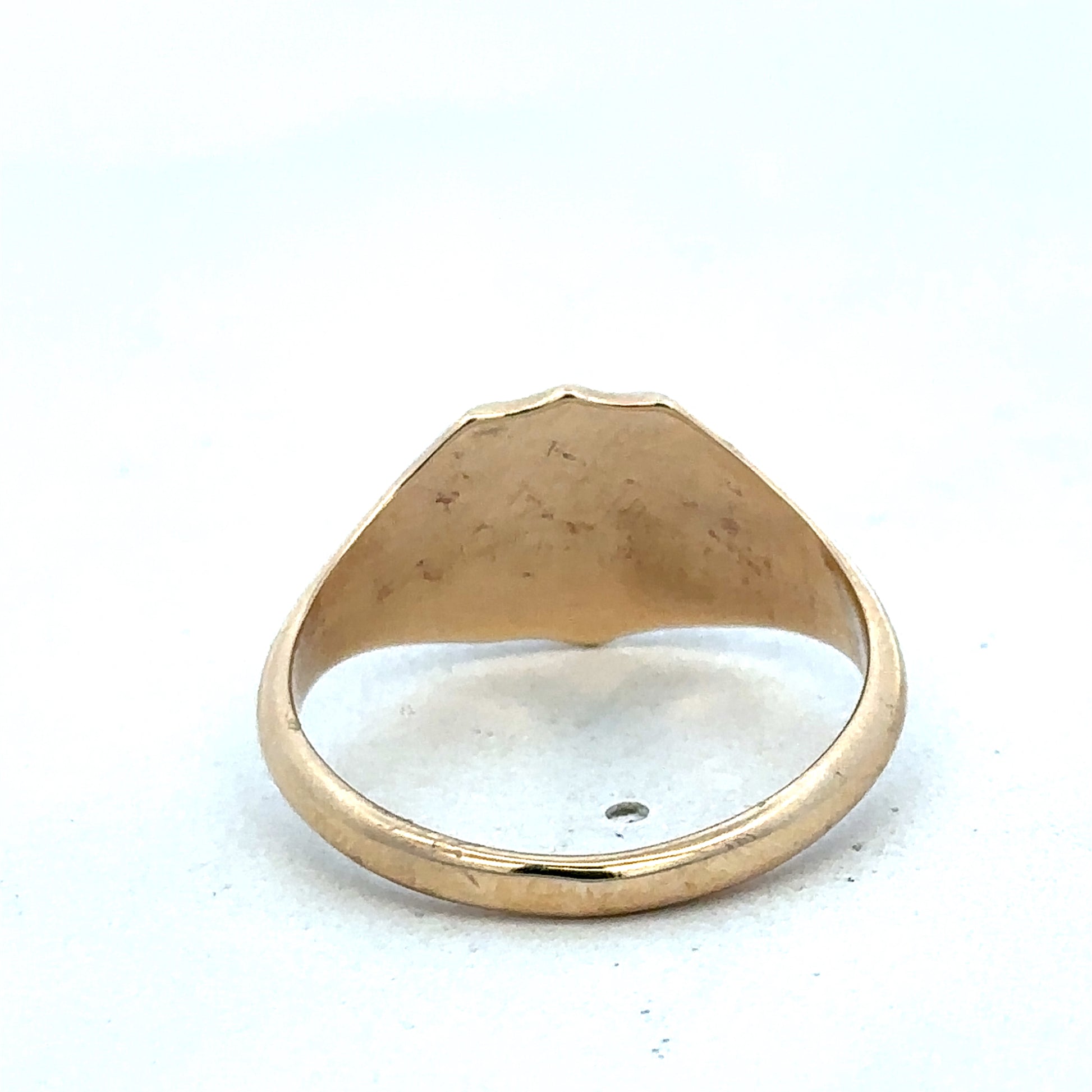 9ct yellow gold signet ring in size T by Reeves and Sons, showing the polished gold surface and classic design.