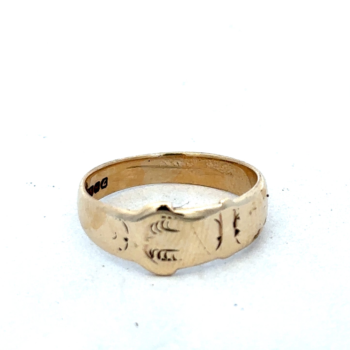 9ct yellow gold buckle ring size L1/2 from Reeves and Sons, featuring a polished gold band with a buckle design.