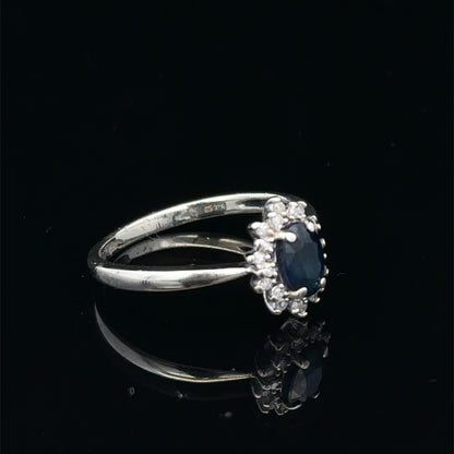9ct white gold sapphire and diamond ring in size L by Reeves and Sons, featuring a central blue sapphire and sparkling diamonds.