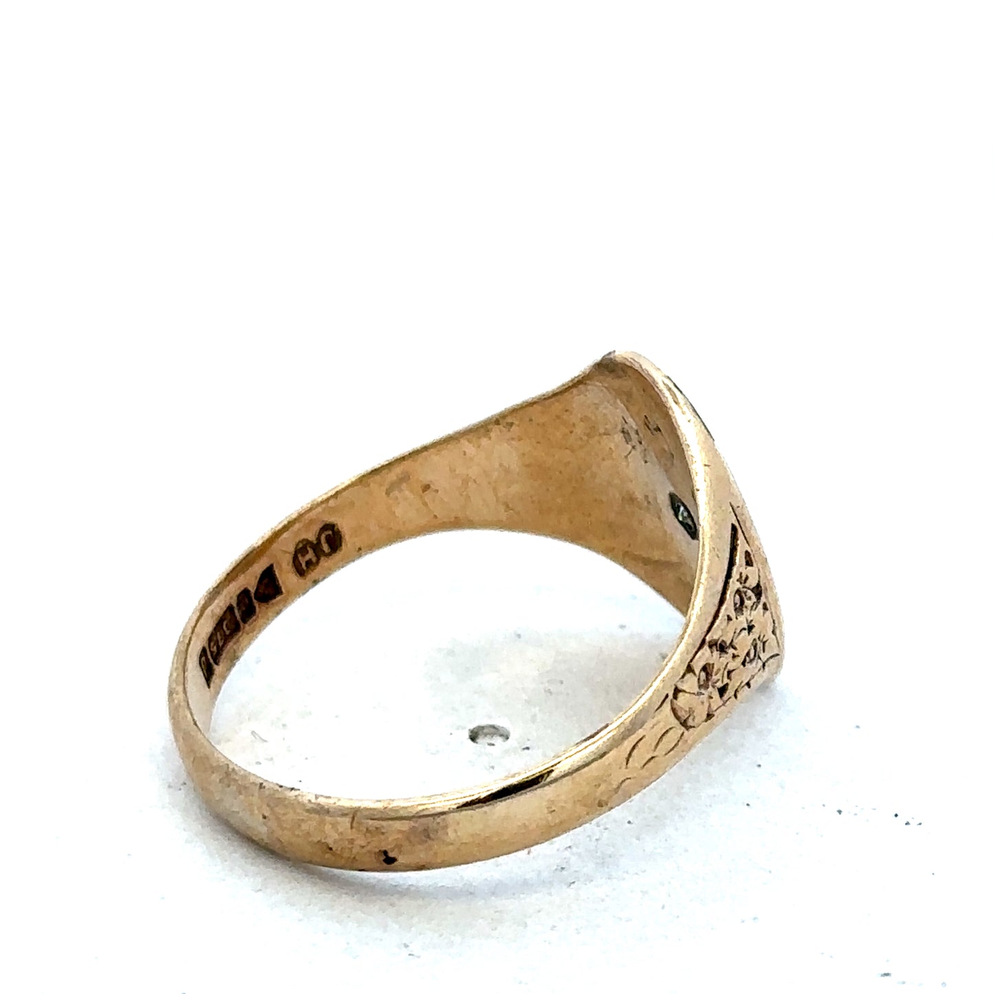 9ct yellow gold signet ring in size U by Reeves and Sons, close-up of polished gold band and engraved face.