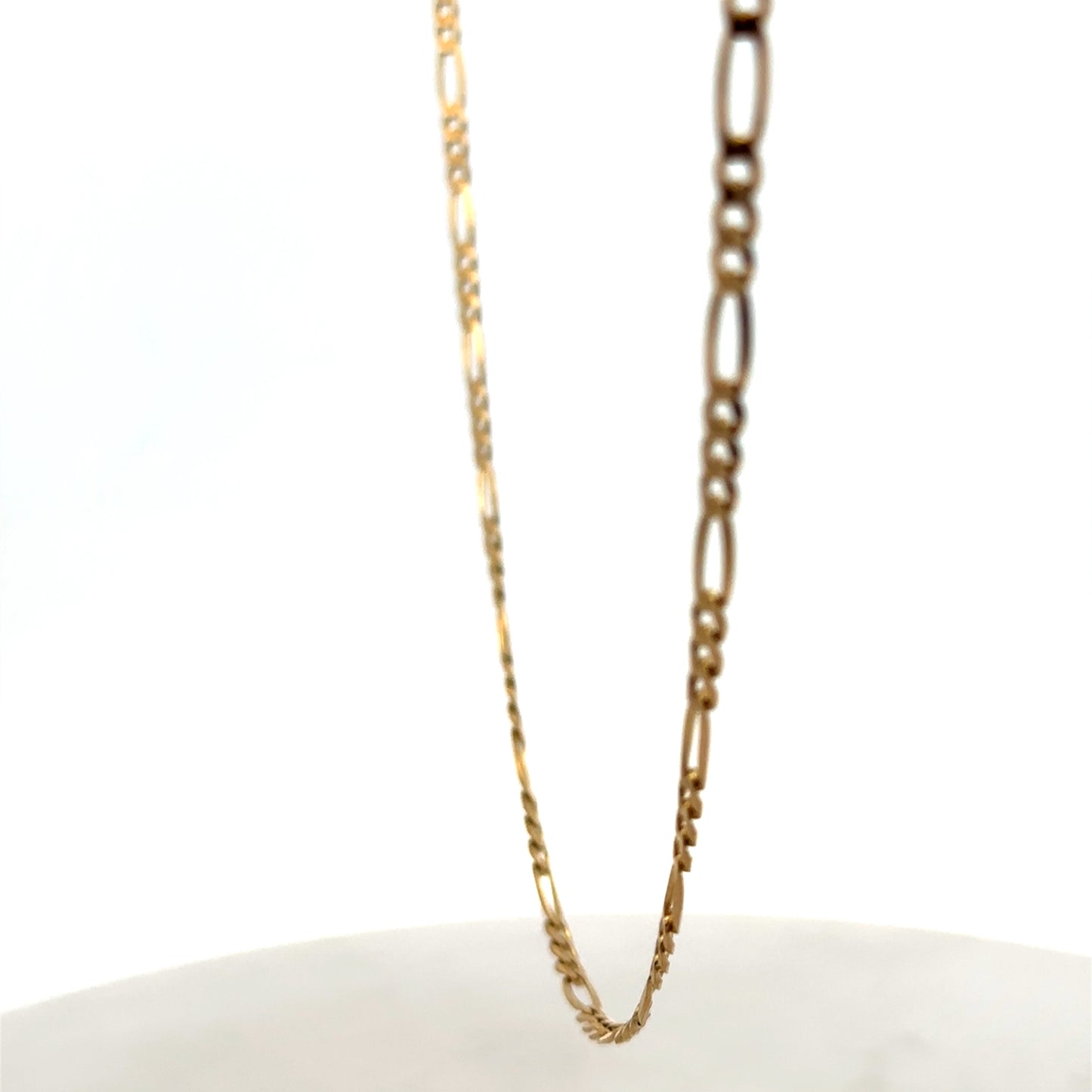 Reeves and Sons 9ct yellow gold figaro chain with a polished finish, weighing 7.1g, displayed on a neutral background.