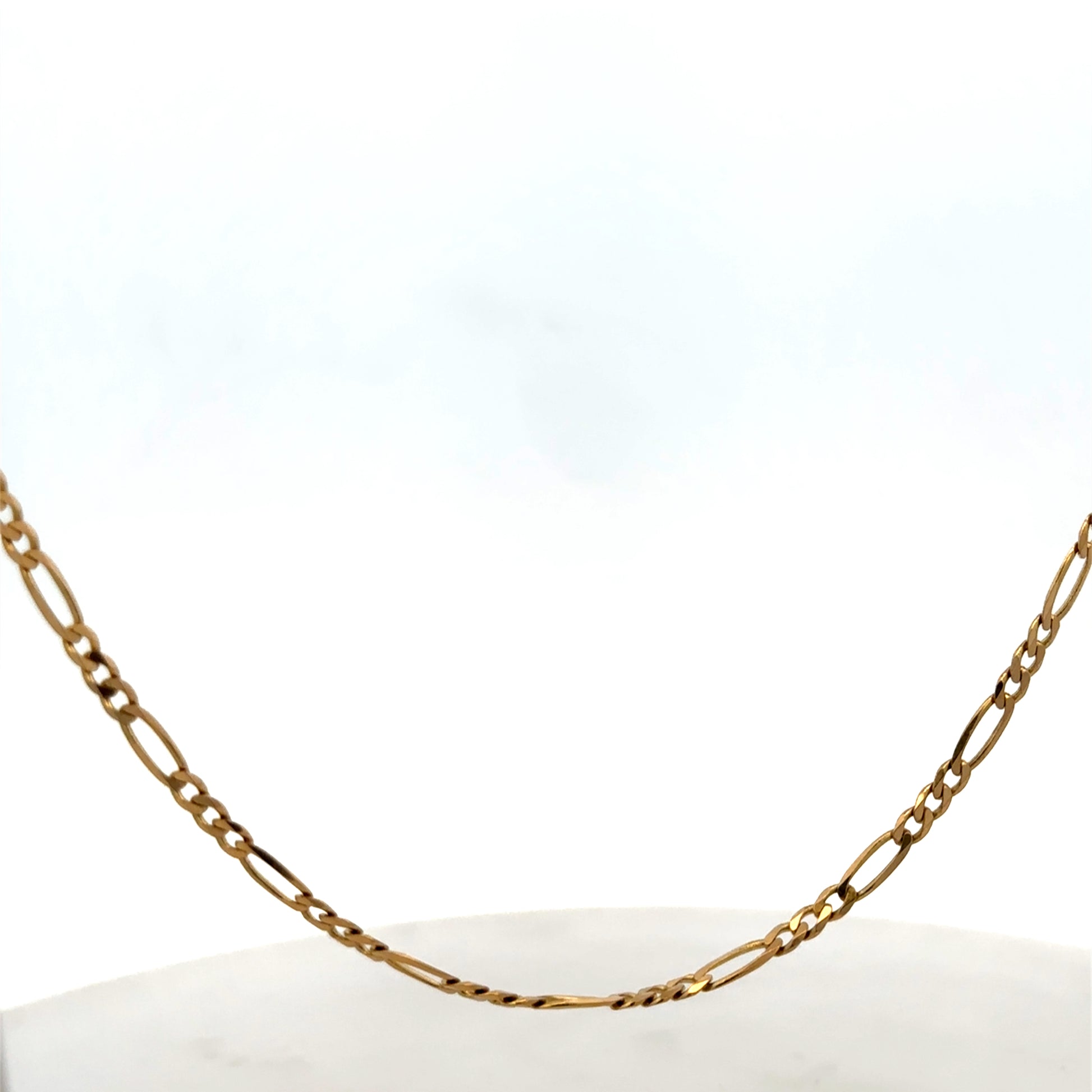 Reeves and Sons 9ct yellow gold figaro chain, 7.1g, showing the chain's detailed linked design and shiny finish.
