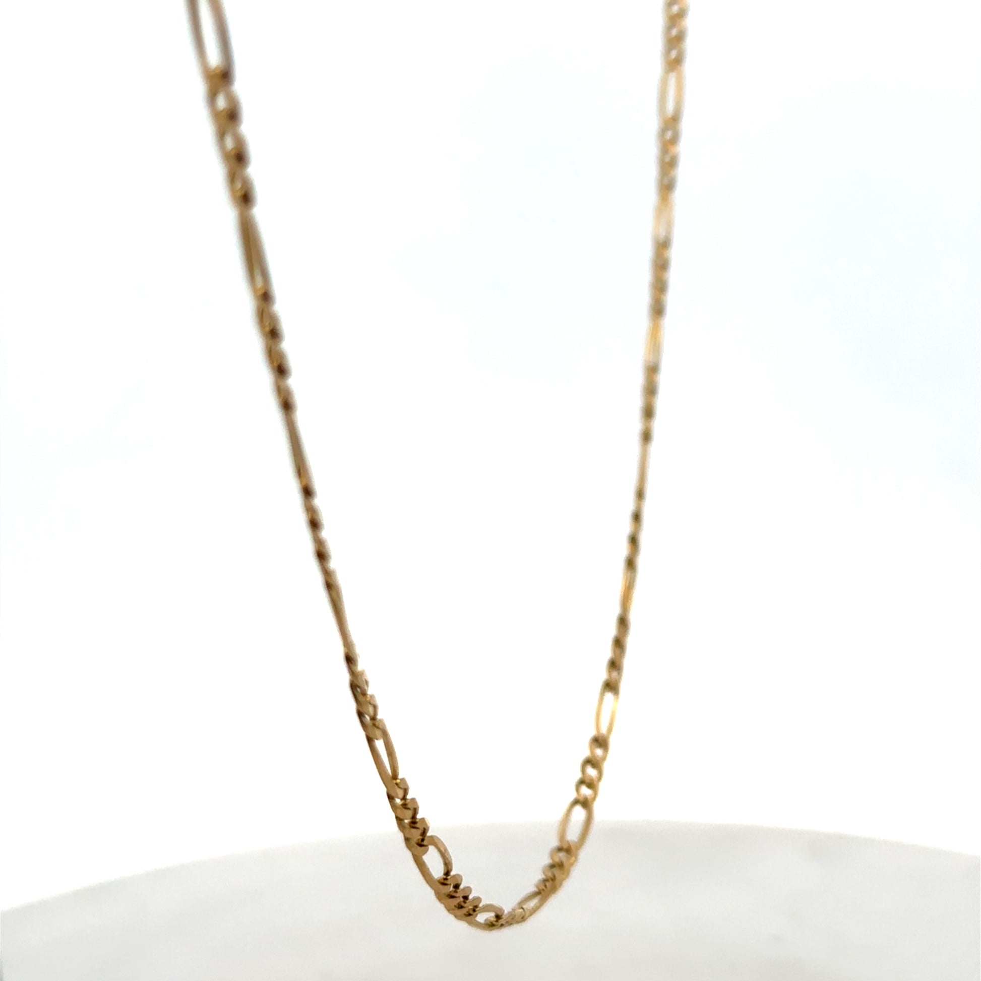 9ct yellow gold figaro chain with intricate links, weight 7.1g, from Reeves and Sons, shown in close-up detail.