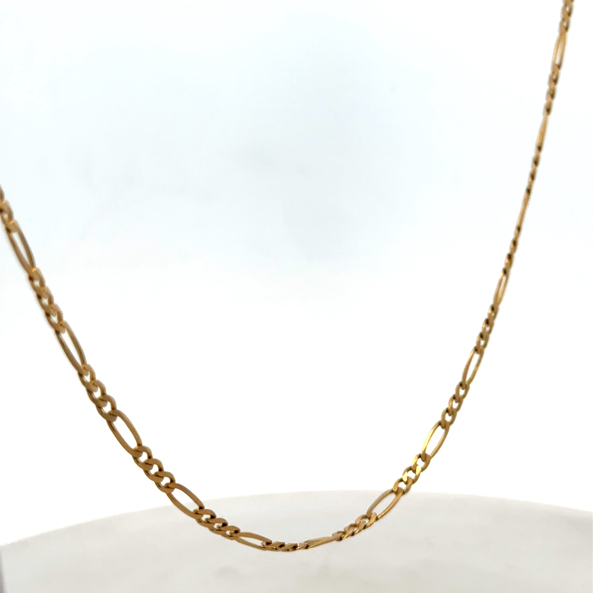9ct yellow gold figaro chain from Reeves and Sons, showing the linked chain design and polished finish.