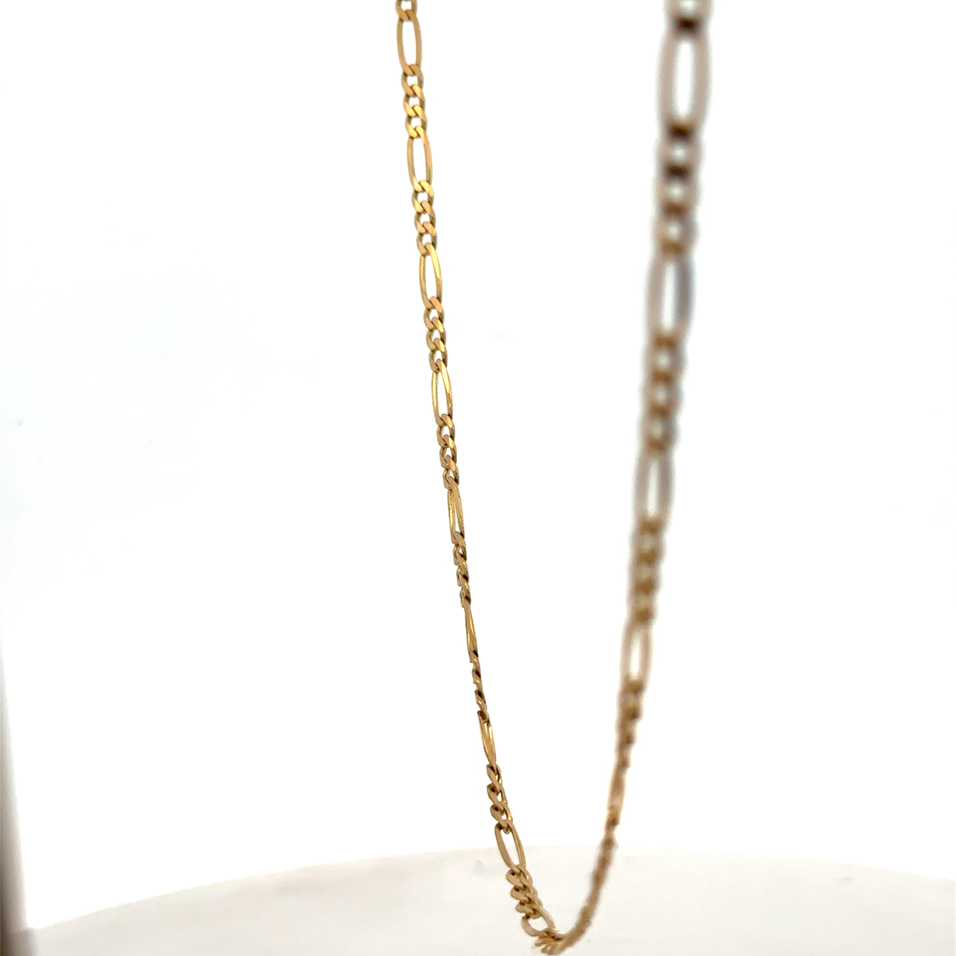9ct yellow gold figaro chain, Reeves and Sons, 7.1g, close-up of shiny gold chain with intricate links.