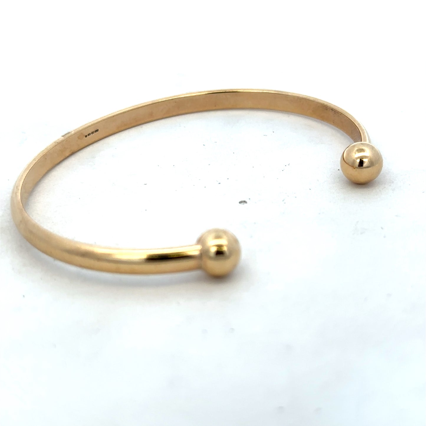 Reeves and Sons 9ct yellow gold bracelet bangle weighing 16.1g, with a smooth polished finish and classic design.
