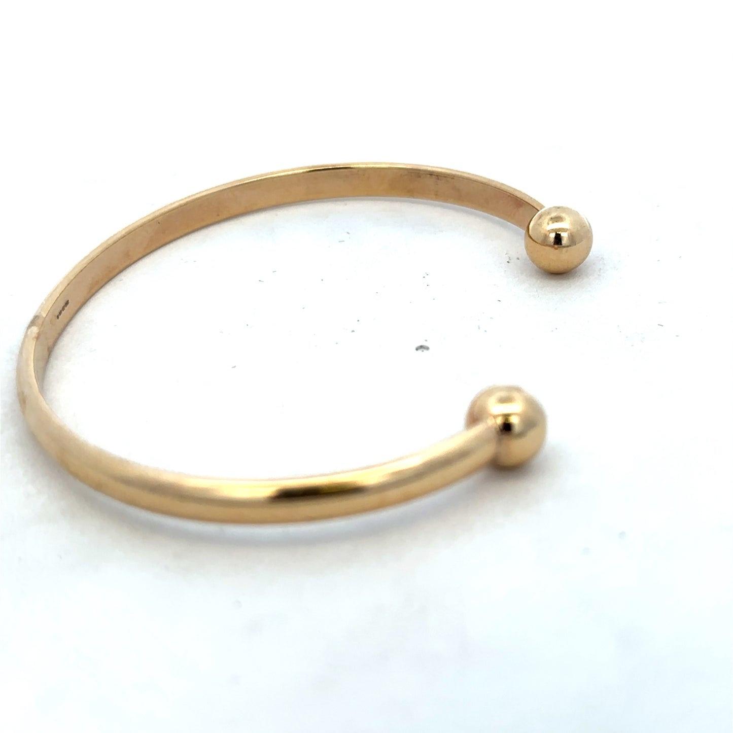 9ct yellow gold bracelet by Reeves and Sons, 16.1g, featuring a sleek and polished bangle design.