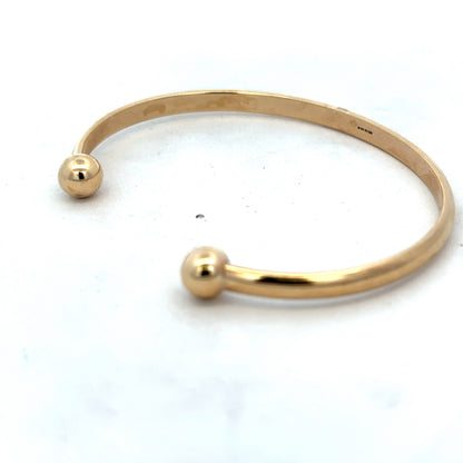 9ct yellow gold bracelet bangle with a smooth, polished finish from Reeves and Sons, weighing 16.1g.