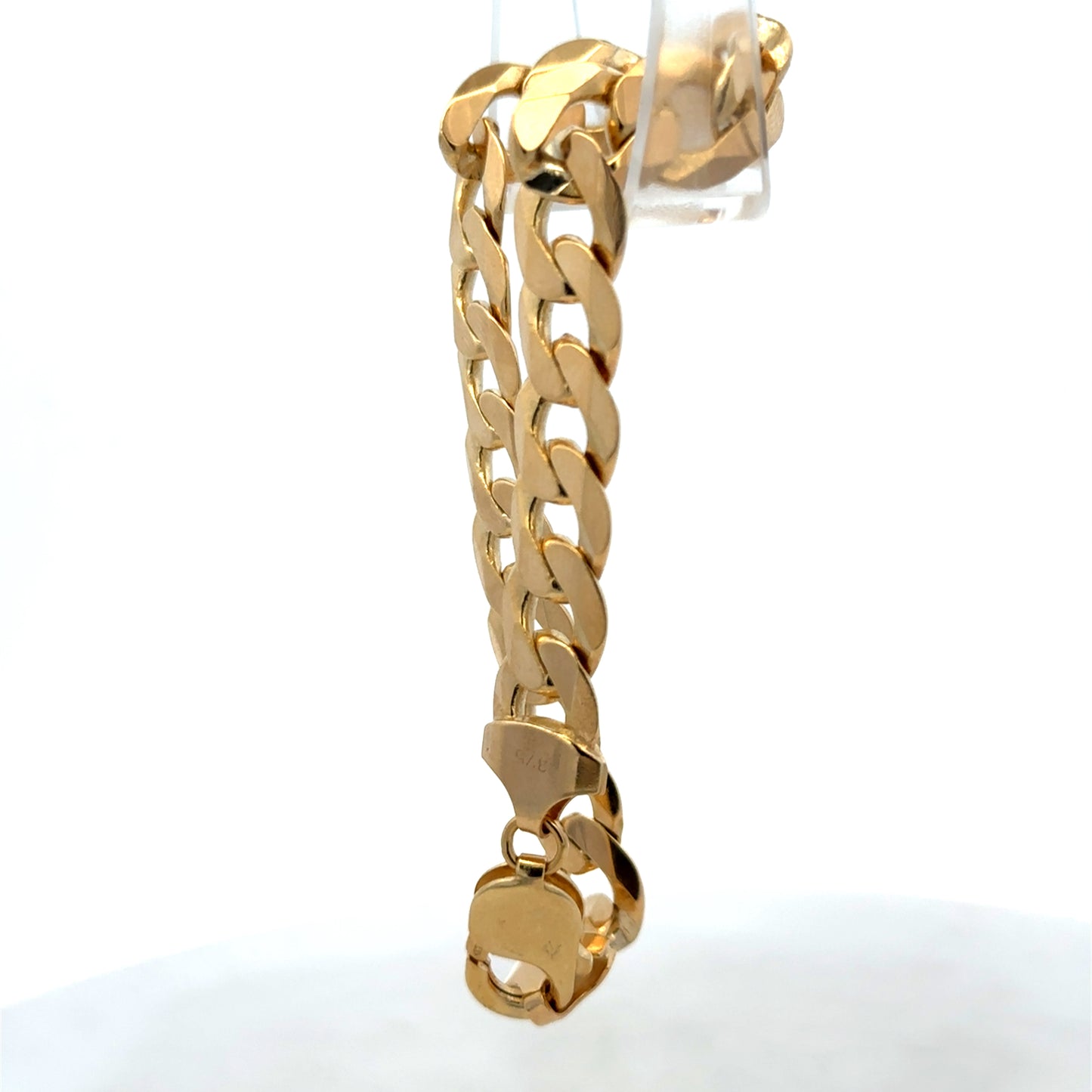 9ct yellow gold curb bracelet weighing 29.9g with linked chain design, by Reeves and Sons, shown in close-up.
