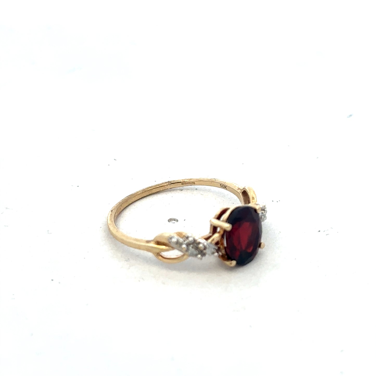 Yellow gold garnet and diamond ring in size R1/2 by Reeves and Sons, showcasing a detailed close-up of the elegant jewelry.