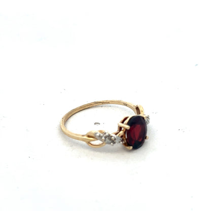 Yellow gold garnet and diamond ring in size R1/2 by Reeves and Sons, showcasing a detailed close-up of the elegant jewelry.