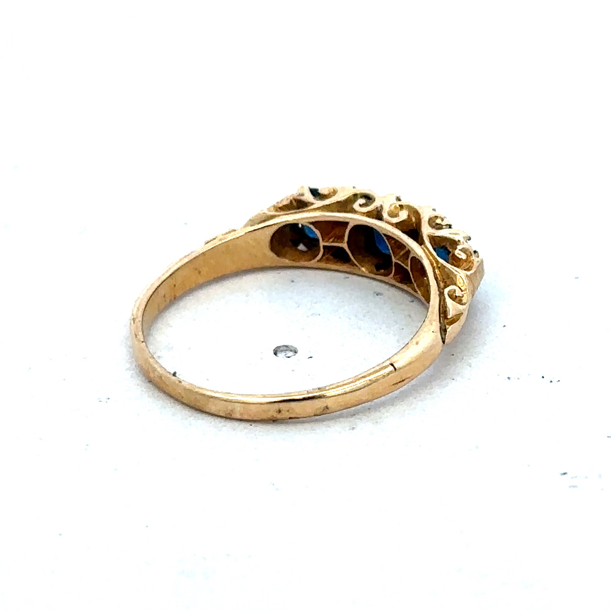 18ct yellow gold sapphire and diamond ring in size O by Reeves and Sons, featuring a central sapphire with diamond accents.