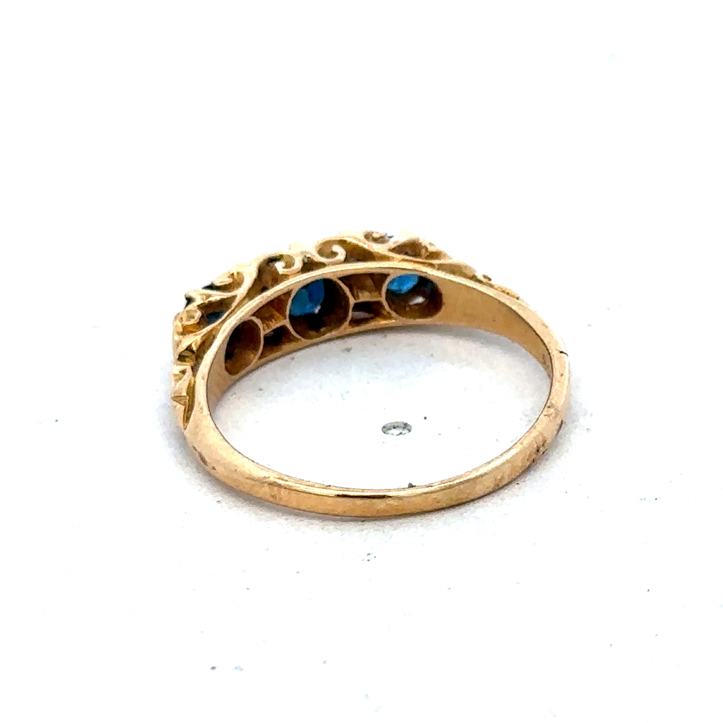 18ct yellow gold sapphire and diamond ring by Reeves and Sons, size O, featuring a central sapphire and sparkling diamonds.