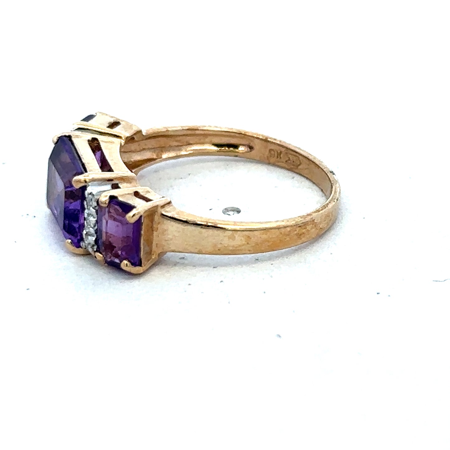 9ct yellow gold amethyst and diamond ring in size N by Reeves and Sons, featuring a central purple gemstone and sparkling accents.
