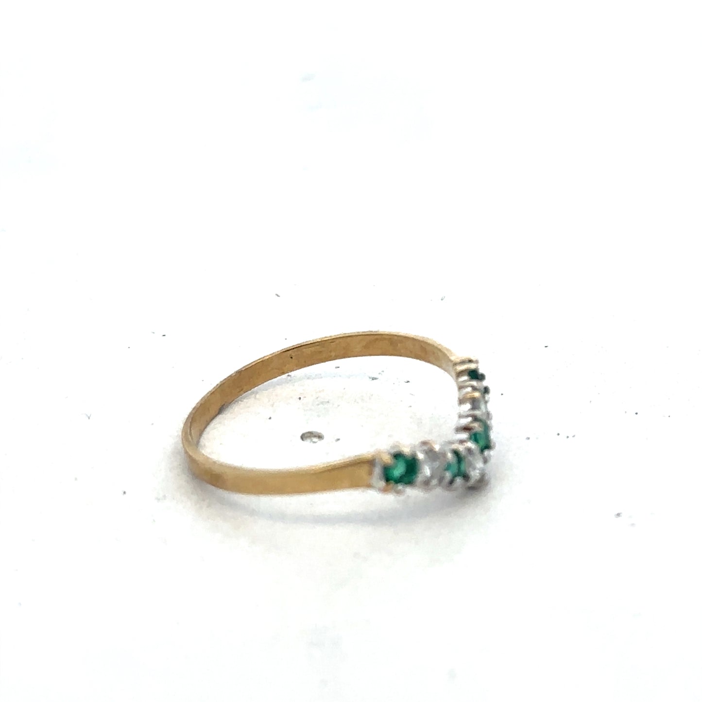 9ct yellow gold emerald and diamond ring by Reeves and Sons featuring a central emerald and sparkling diamonds in size O1/2.
