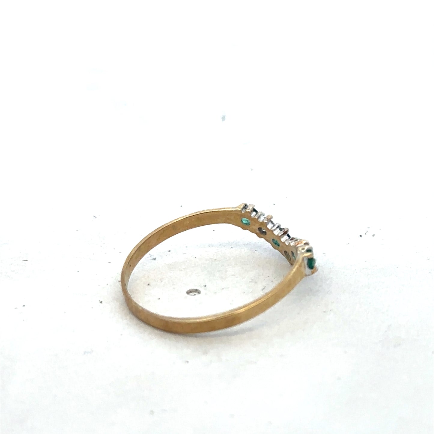 9ct yellow gold emerald and diamond ring with intricate band design, size O1/2, by Reeves and Sons, shown in close-up.