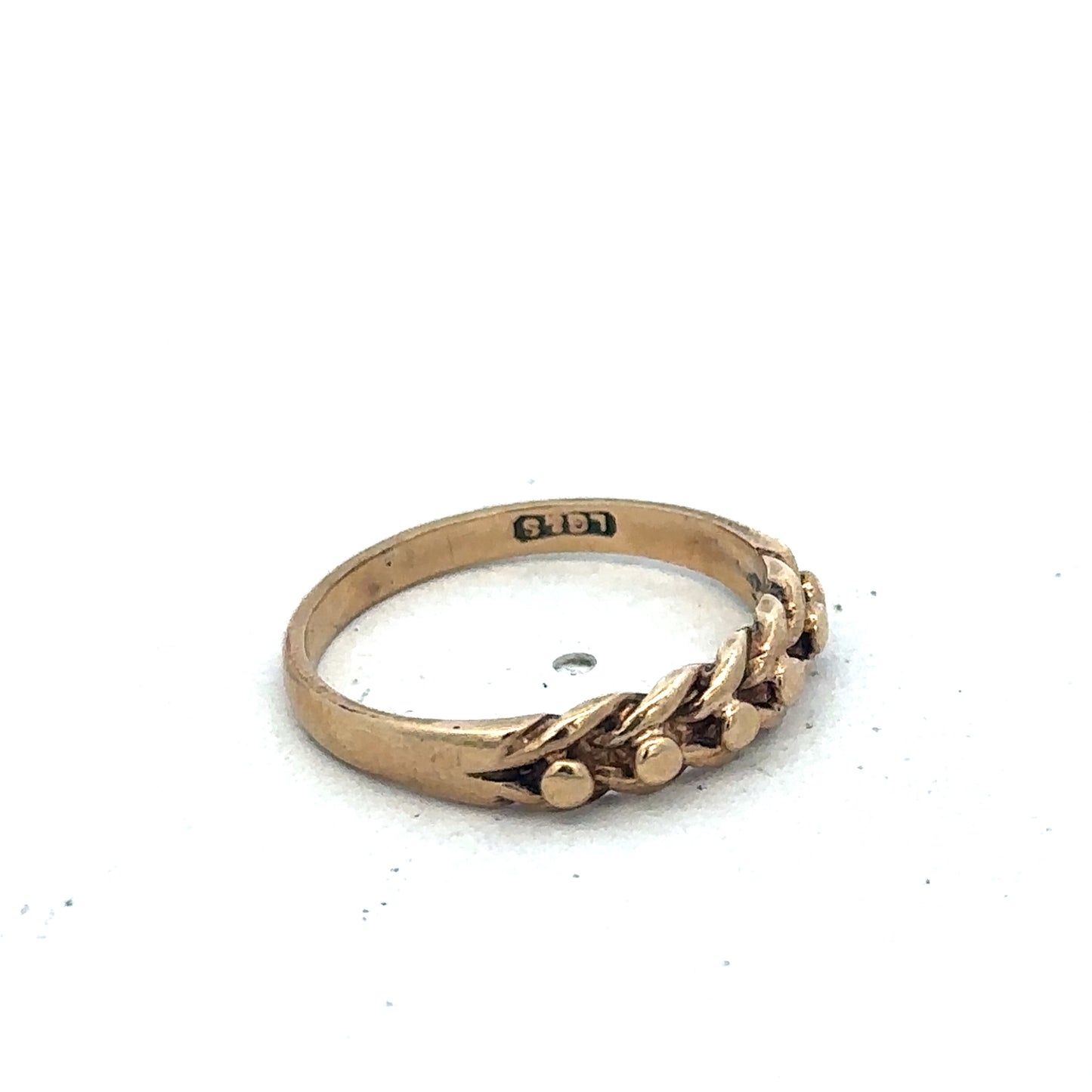 9ct yellow gold keeper ring in size K with textured band, crafted by Reeves and Sons, shown from a side angle.