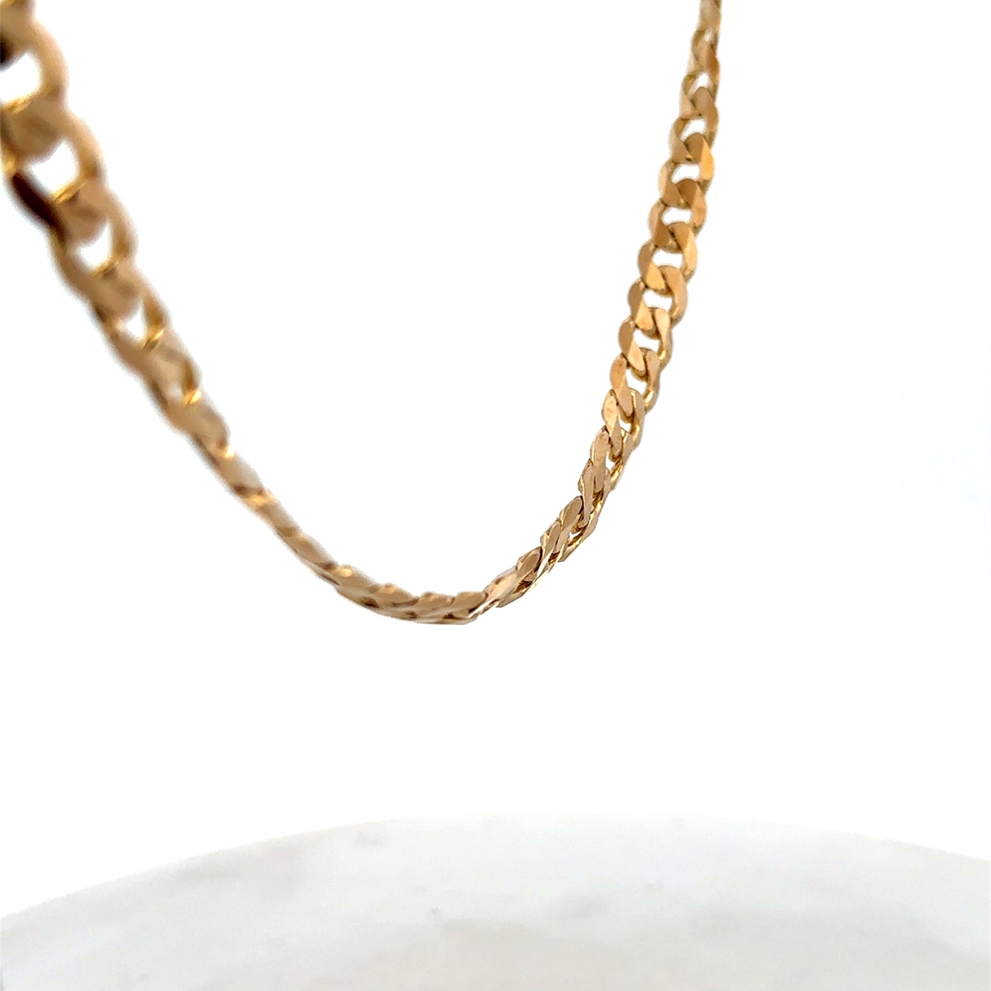 9ct yellow gold curb chain weighing 44.3g with a classic link design, crafted by Reeves and Sons.