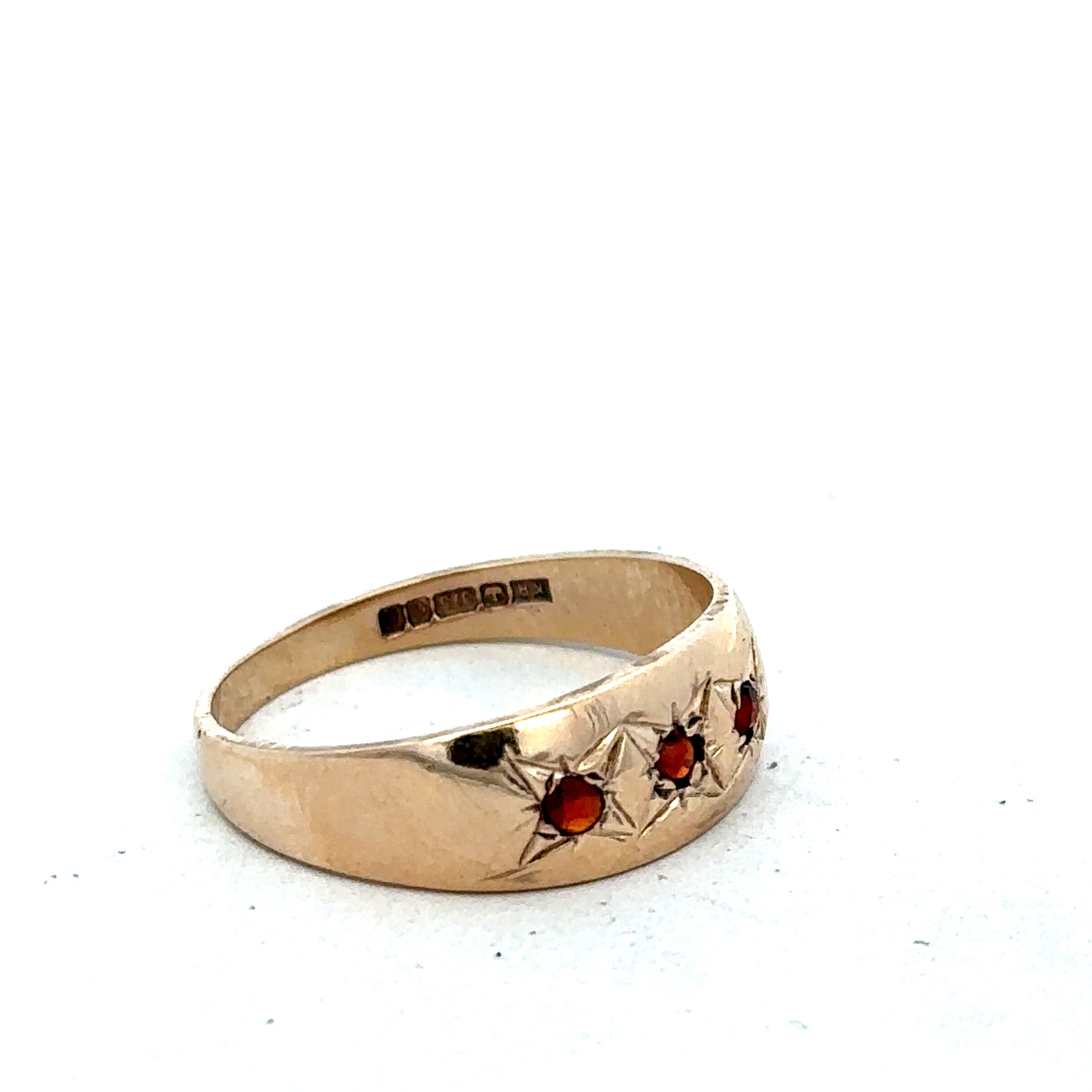 9ct yellow gold garnet ring in size N with a polished band and a central deep red garnet gemstone.