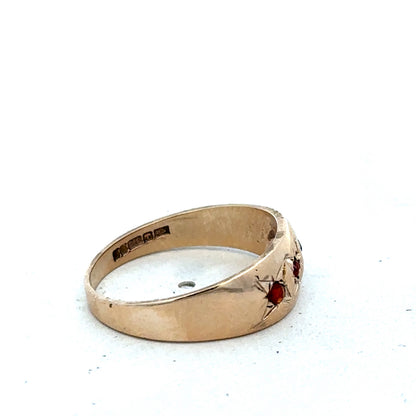 Yellow gold garnet ring in size N by Reeves and Sons, featuring a central deep red garnet gemstone.