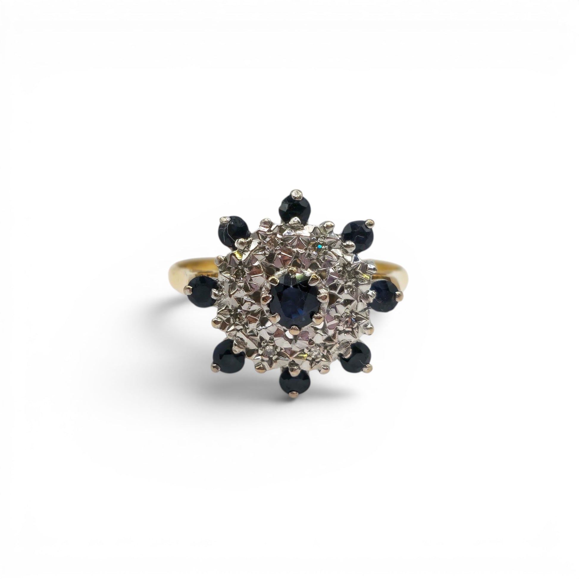 18ct yellow gold sapphire and diamond cluster ring with intricate design, featuring sparkling gemstones and Reeves and Sons branding.