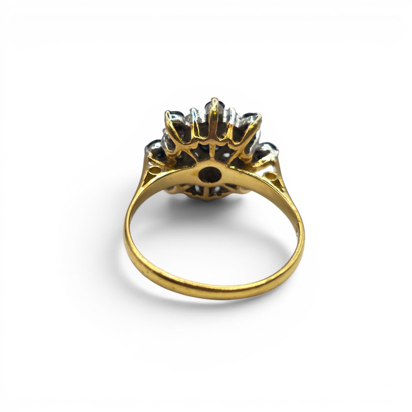 18ct yellow gold sapphire and diamond cluster ring by Reeves and Sons, featuring a vibrant sapphire centerpiece and sparkling diamonds.
