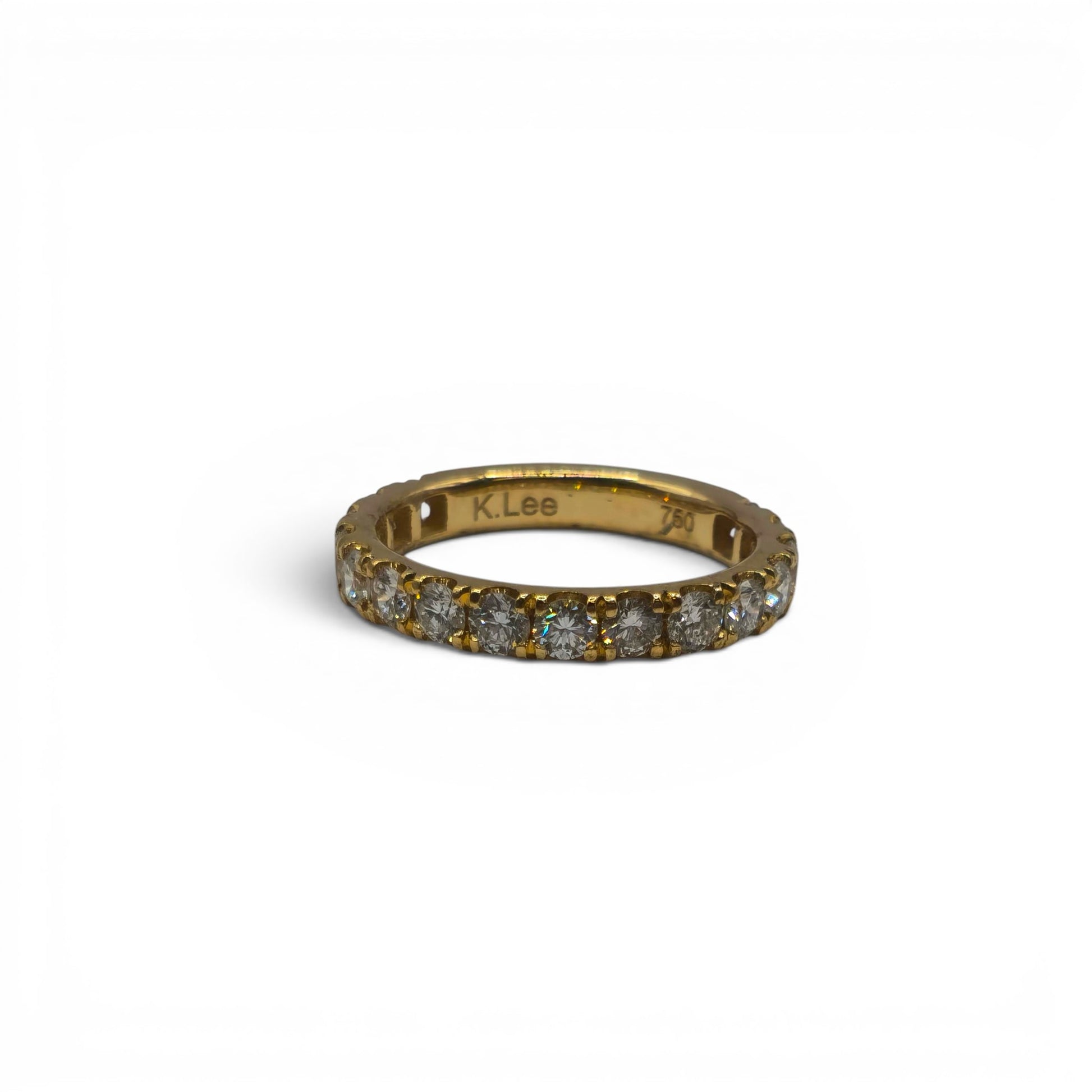 18ct yellow gold diamond eternity ring by Reeves and Sons, featuring a continuous row of sparkling diamonds on a sleek band.