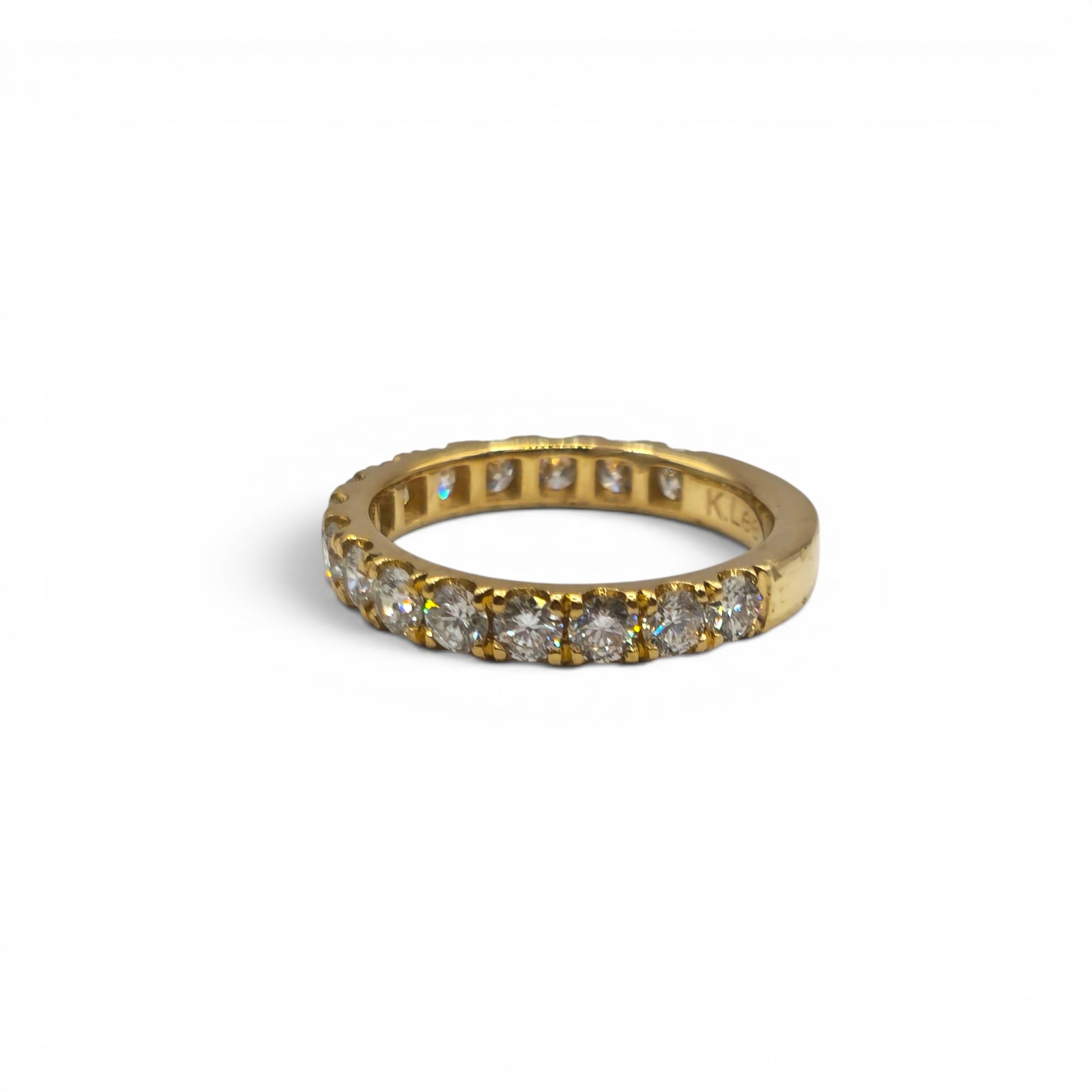 18ct yellow gold diamond eternity ring by Reeves and Sons, showcasing a continuous row of sparkling diamonds on a sleek band.