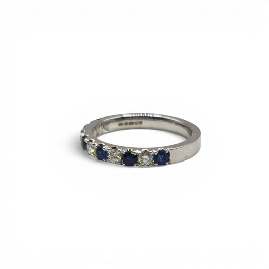 18ct white gold sapphire and diamond half eternity ring by Reeves and Sons, featuring blue sapphires and sparkling diamonds.
