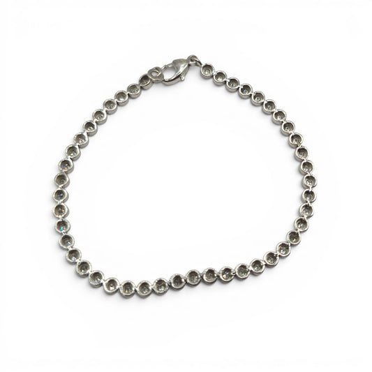 9ct white gold diamond line bracelet by Reeves and Sons, featuring a delicate chain with sparkling diamonds, shown on a white background.