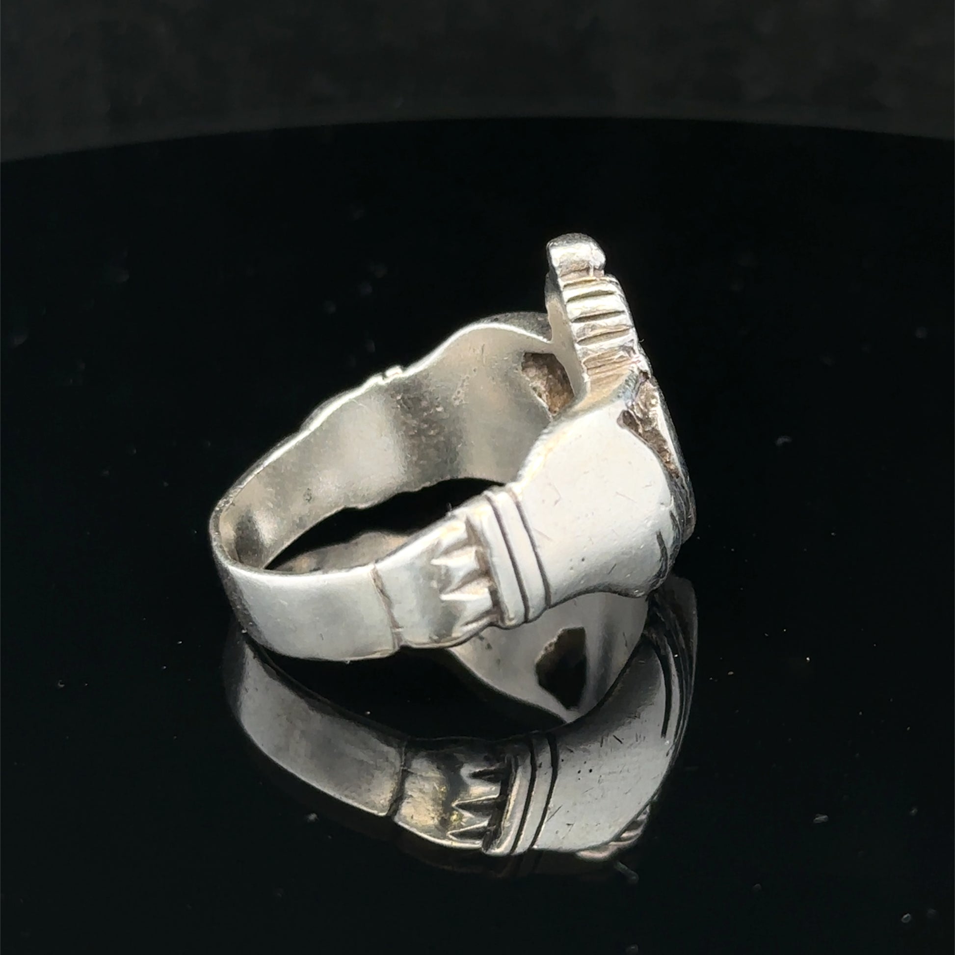 Silver Claddagh ring in size Z1 by Reeves and Sons, featuring a detailed heart and crown design, resting on a neutral background.