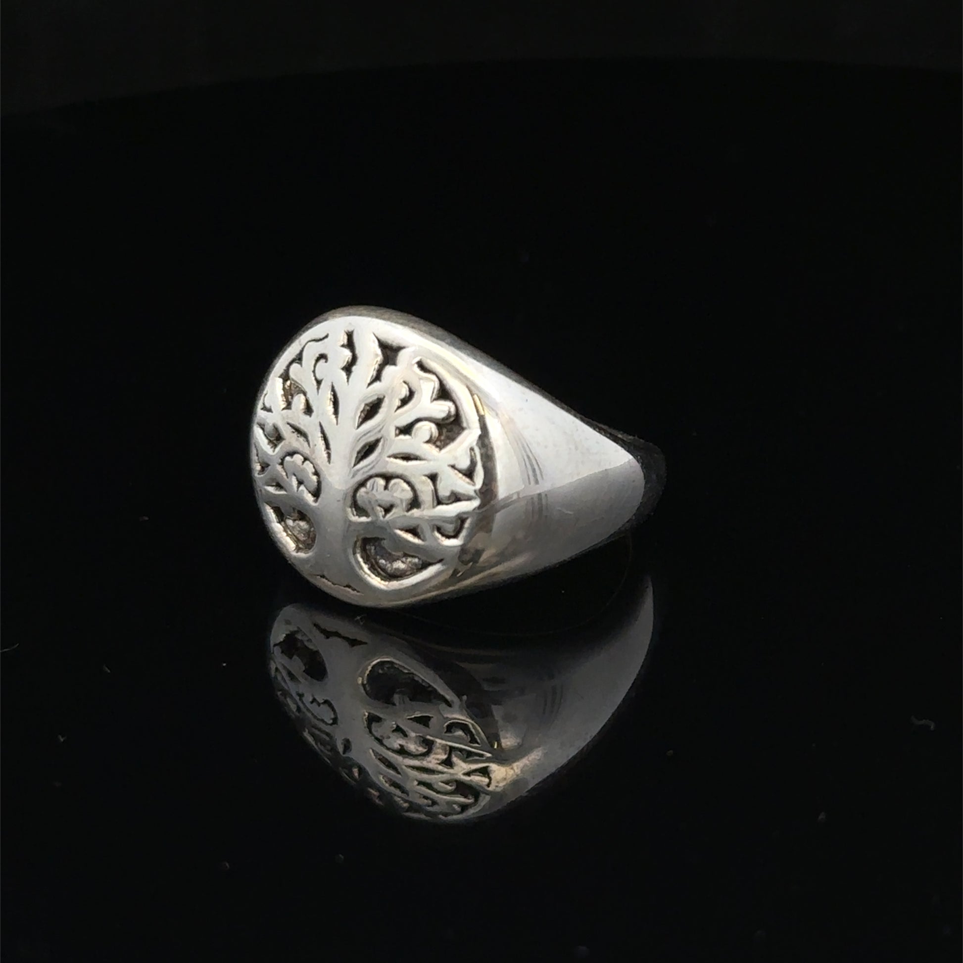 Silver ring size P by Reeves and Sons, showing the detailed band design and shiny finish.
