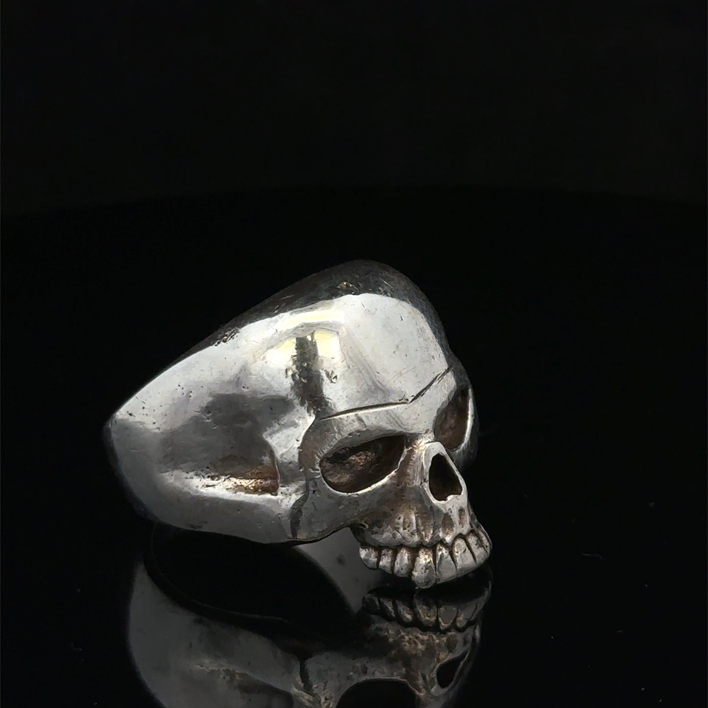 Silver skull ring by Reeves and Sons, size Z1, featuring a detailed skull design in polished metal.