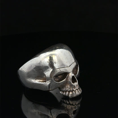 Silver skull ring by Reeves and Sons, size Z1, featuring a detailed skull design in polished metal.