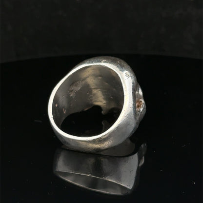 Silver skull ring by Reeves and Sons, size Z1, featuring detailed skull design, polished finish, and stylish jewelry craftsmanship.