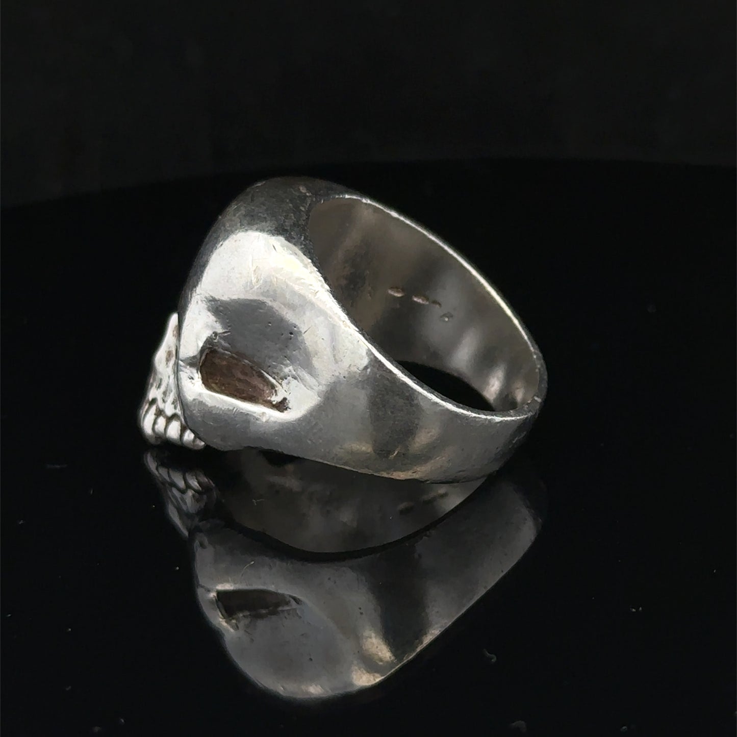 Silver skull ring by Reeves and Sons, size Z1, featuring detailed skull design, set against a plain background.