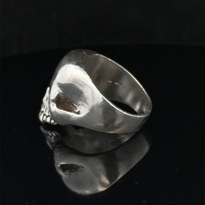 Silver skull ring by Reeves and Sons, size Z1, featuring detailed skull design, set against a plain background.