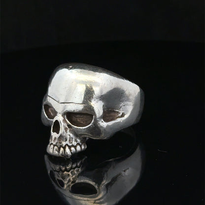 Silver skull ring from Reeves and Sons in size Z1, featuring detailed skull design on a sleek band.