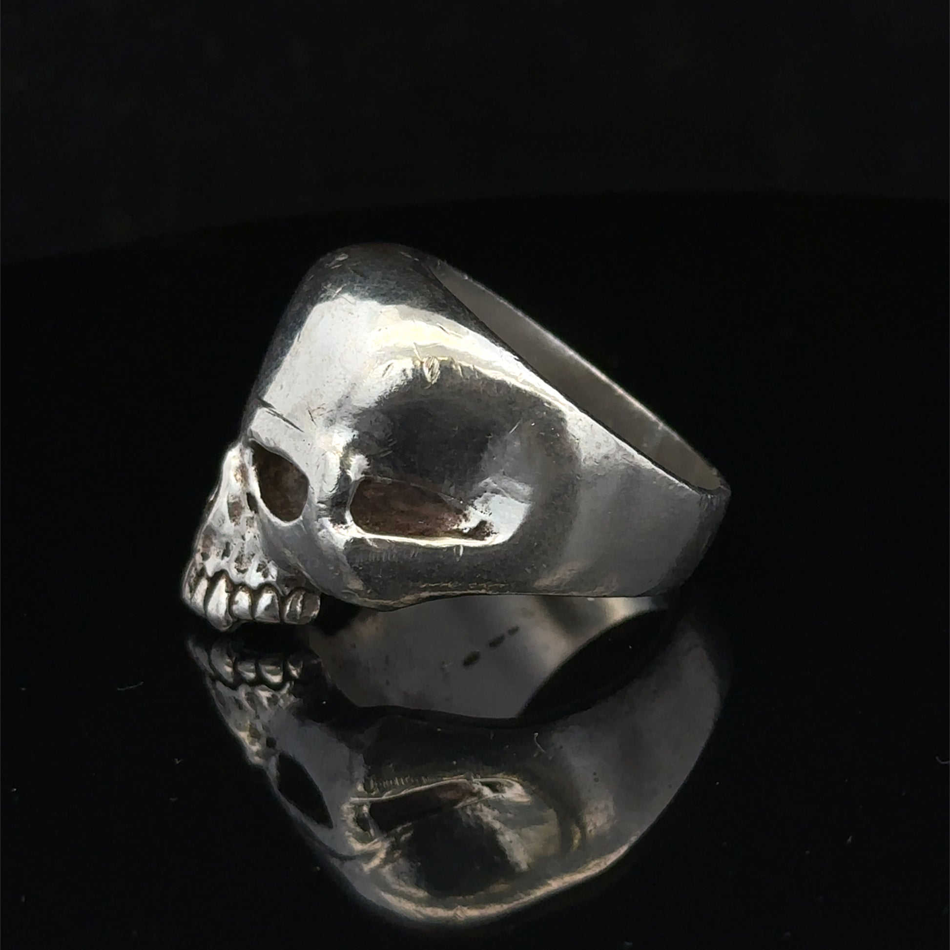 Silver skull ring by Reeves and Sons, size Z1, featuring a detailed skull design on a polished band.