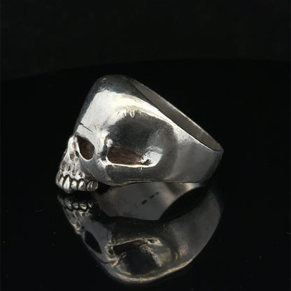 Silver skull ring by Reeves and Sons, size Z1, featuring a detailed skull design on a polished band.