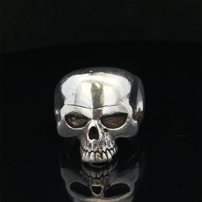Silver skull ring in size Z1 by Reeves and Sons, featuring detailed skull design on a polished band.