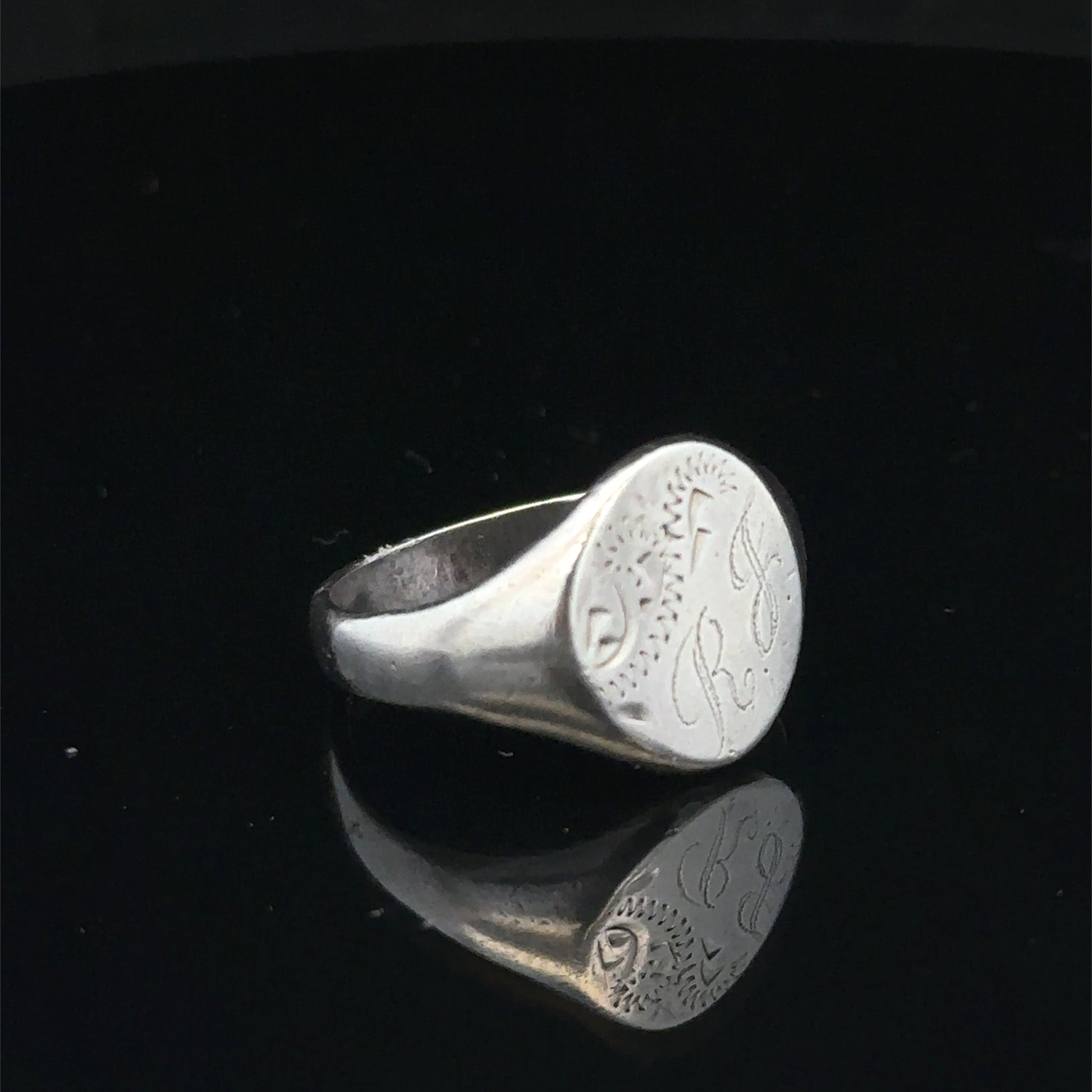 Silver signet ring from Reeves and Sons, size S1/2, featuring a polished band and classic design.