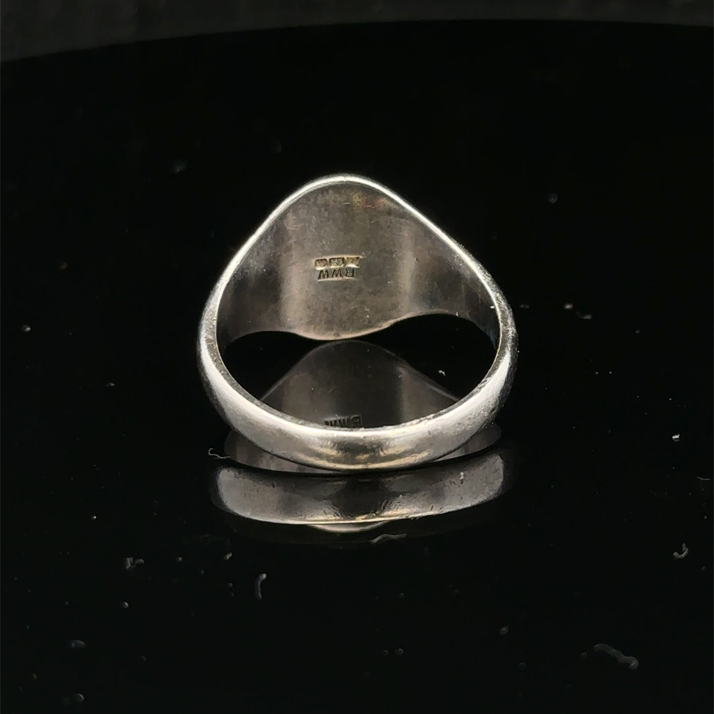 Silver signet ring with engraved design, size S1/2, from Reeves and Sons, shown on a neutral background.
