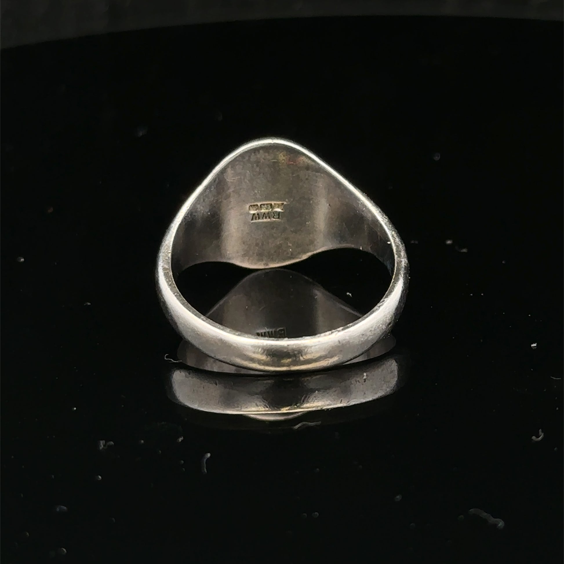 Silver signet ring with engraved design, size S1/2, from Reeves and Sons, shown on a neutral background.